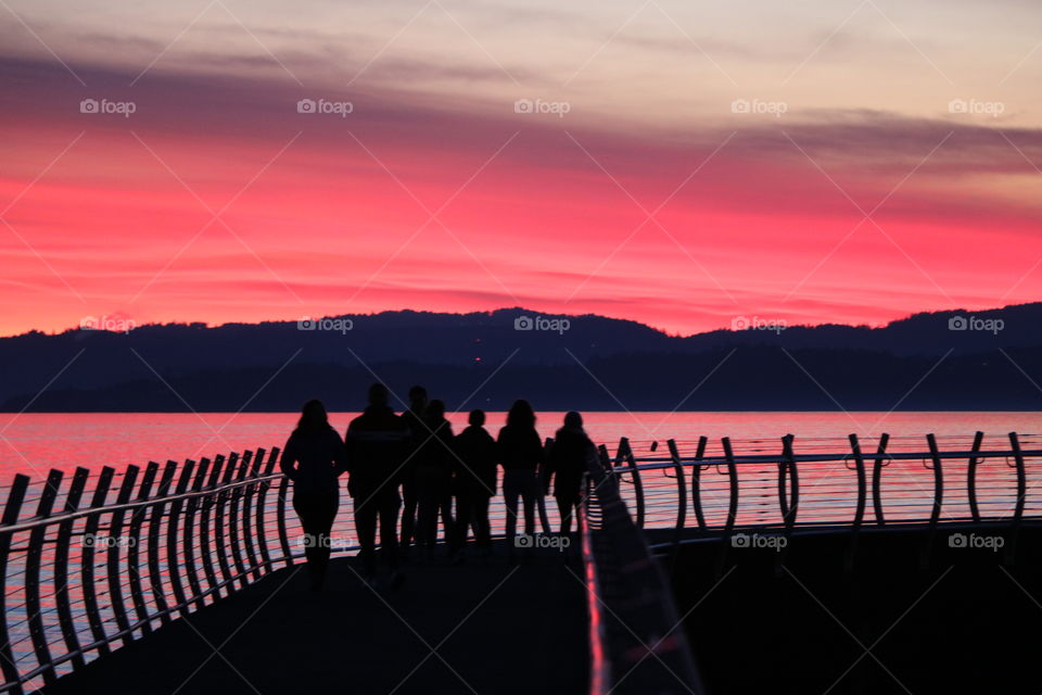 Walking on breakwater with friends on sunset , watching the colours of the sky changing 