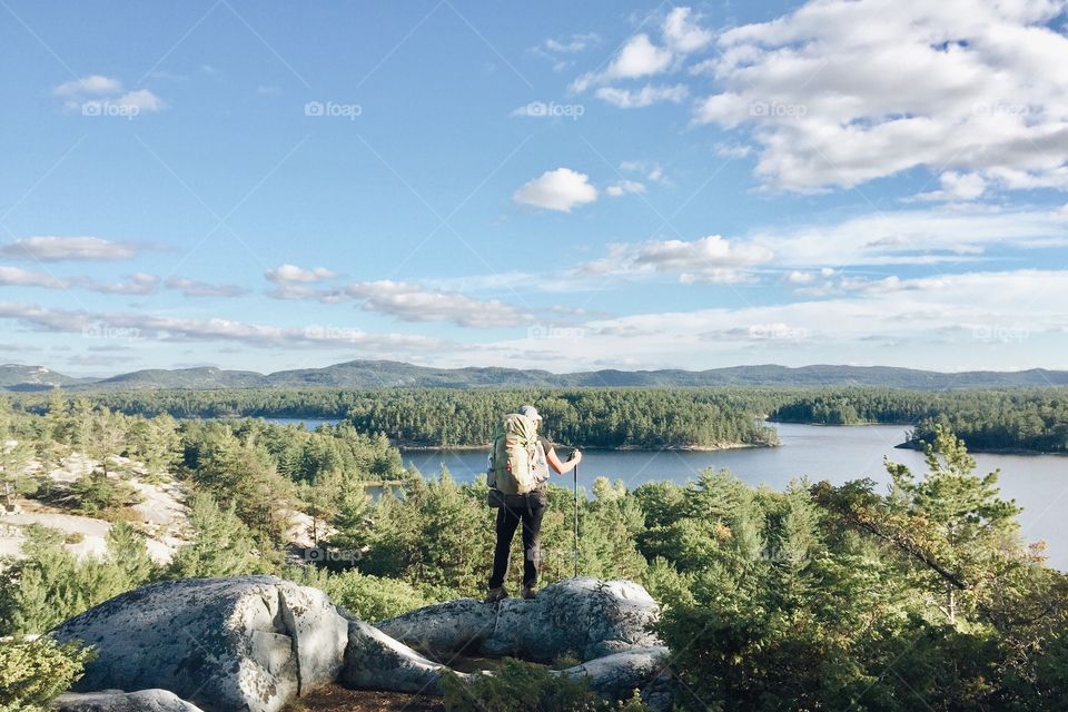 Hiker looking out at a landscape view of lakes and hills