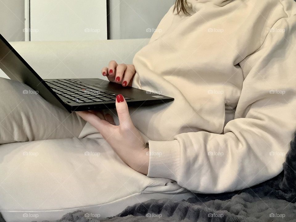 Hands with red manicure on laptop