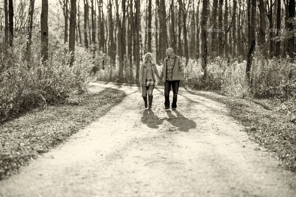 Cute couple walking down a dirt road holding hands 