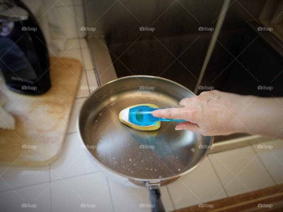 Handy Woman Cleaning a Pan