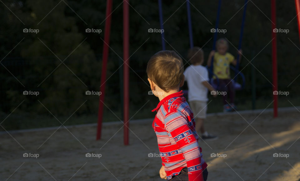 Boy looks like other children chat, the concept of loneliness, friendship