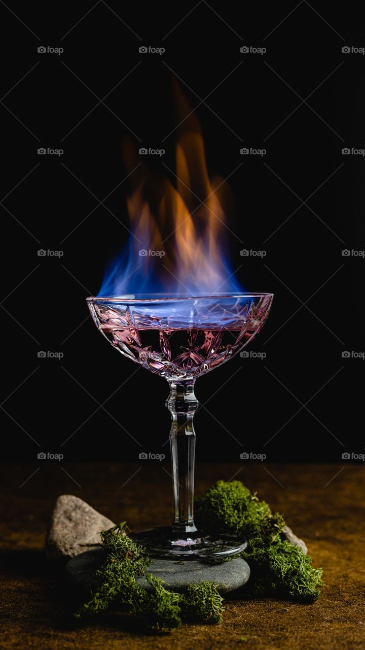 Pink cocktail with a blue fire