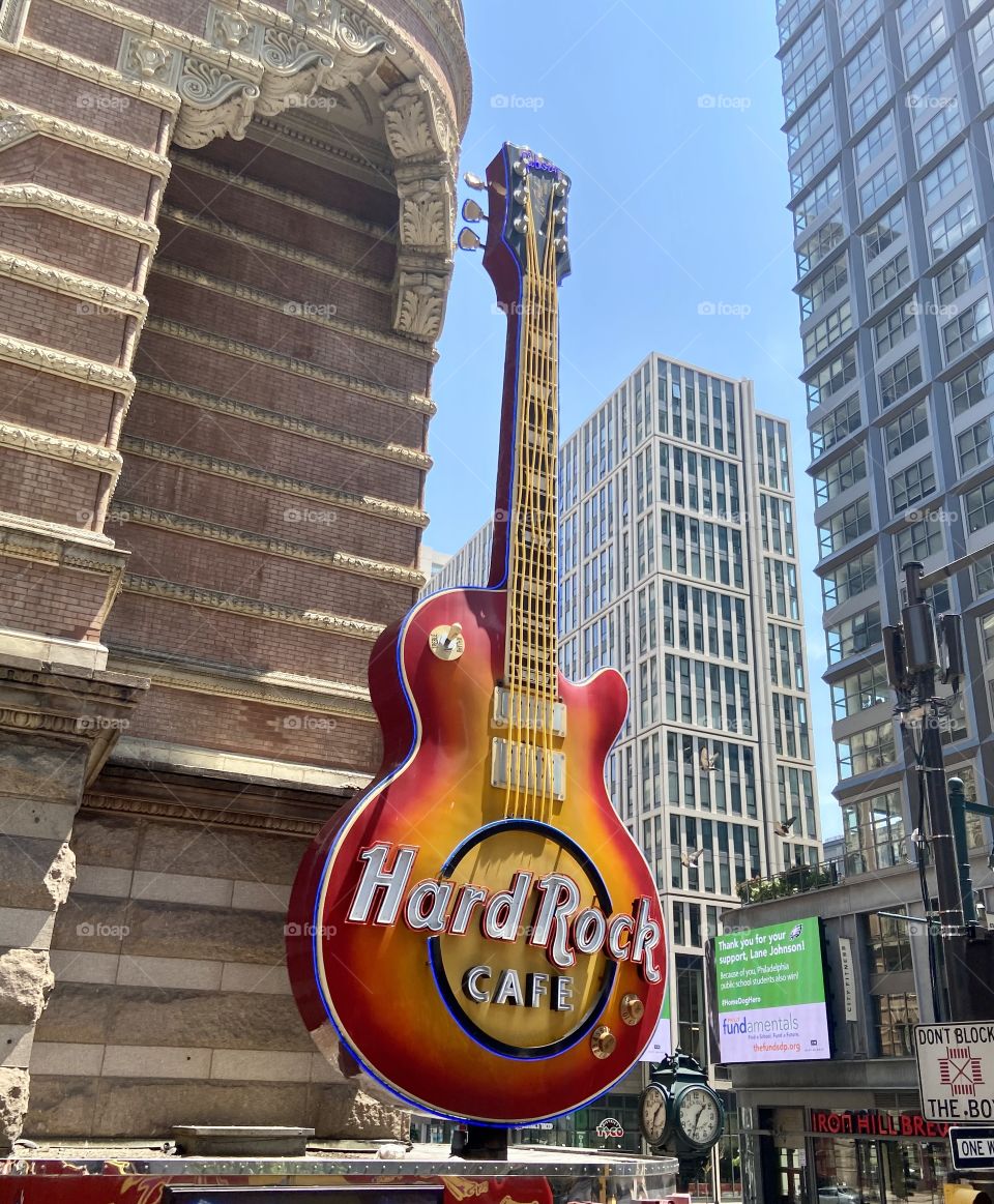 A huge replica of a guitar amongst city buildings advertising Hard Rock Cafe