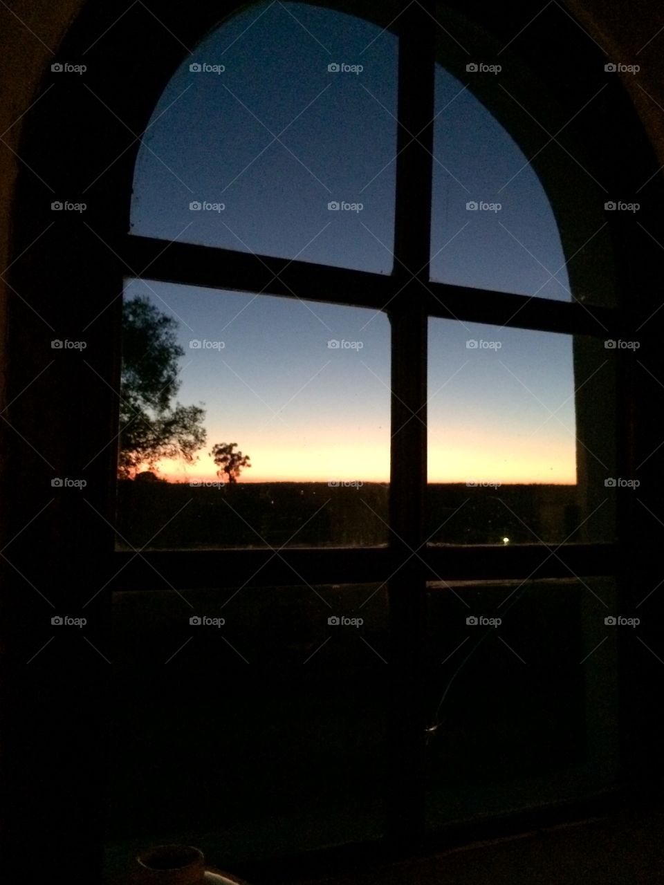 View of a sunset through the window at Monte das Hortas, Portugal.