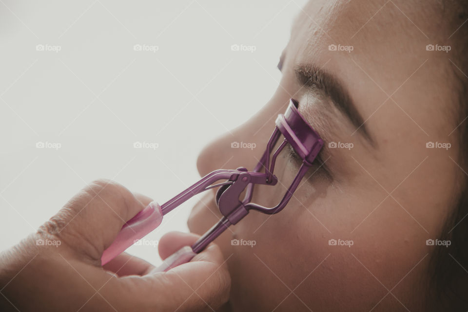 A face makeup process, eyelash curler using on Asian female