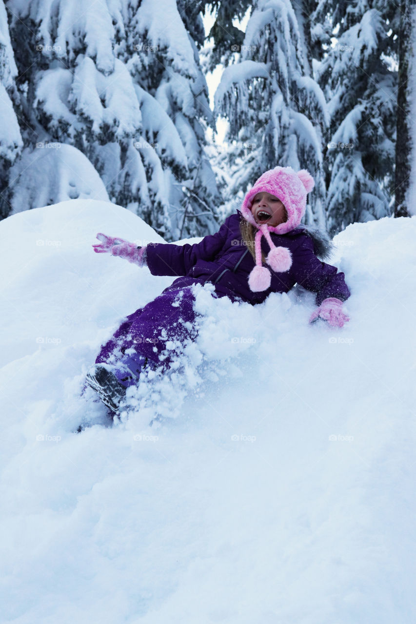 Child sliding down a hill of snow