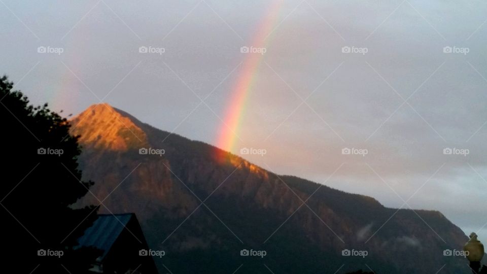 Mountain Shooting Rainbow. After a lengthy rain, the skies cleared and a rainbow appeared to be shooting out of Mt. Crested Butte, Colorado.