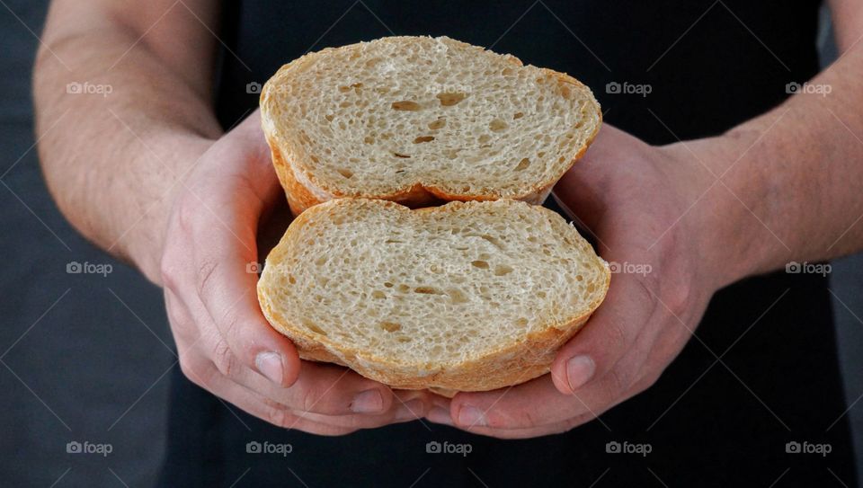 cut bread in the hands of a man