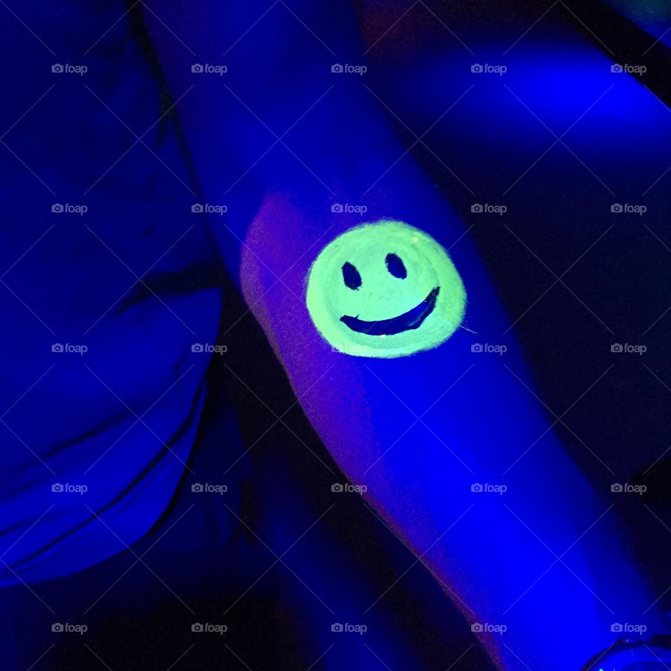 Neon smiley face bodyart