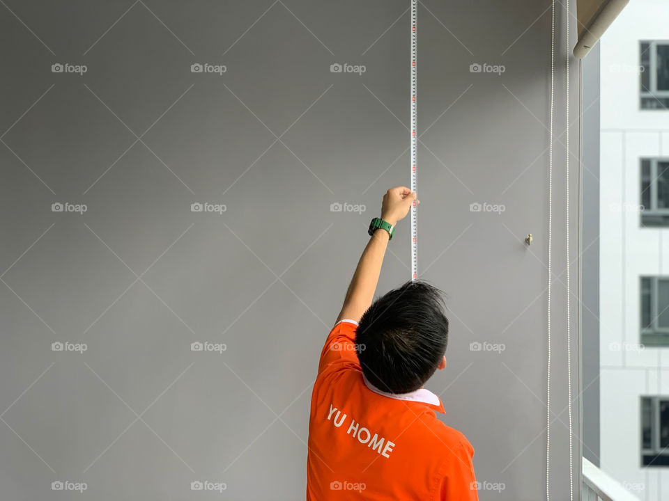 Worker man taking measurements of home 