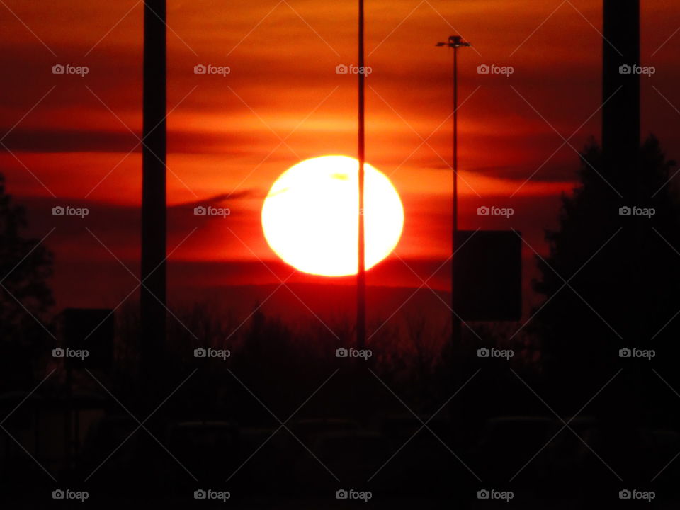 red sunrise over a metropolitan airport, sun, clouds,