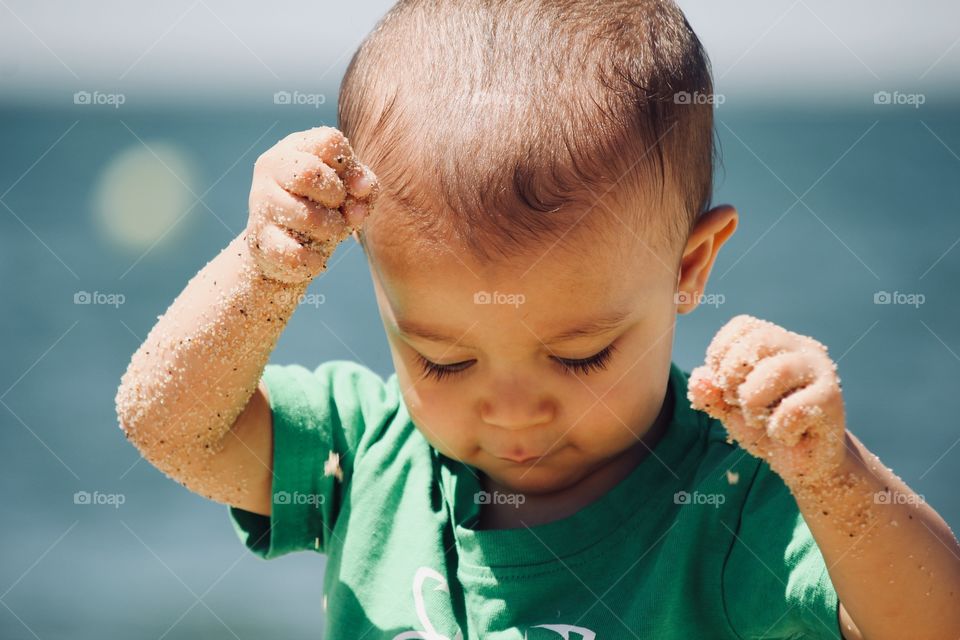 Baby playing with sand on the beach