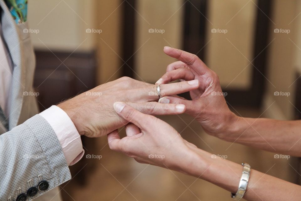 Bride putting ring on broom's finger