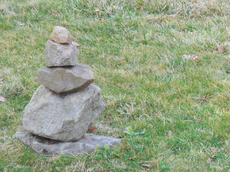 Stacked stones on left side green grass springtime