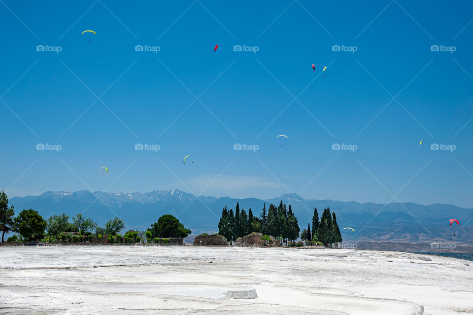 Paragliding above white like snow terraces of Pamukkale. Travertines of Pamukkale. Turkey.