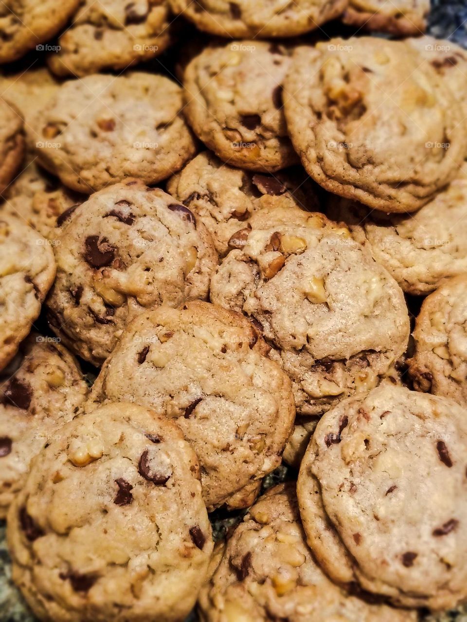 Pile of delicious fresh baked homemade chocolate chip cookies with pecans 