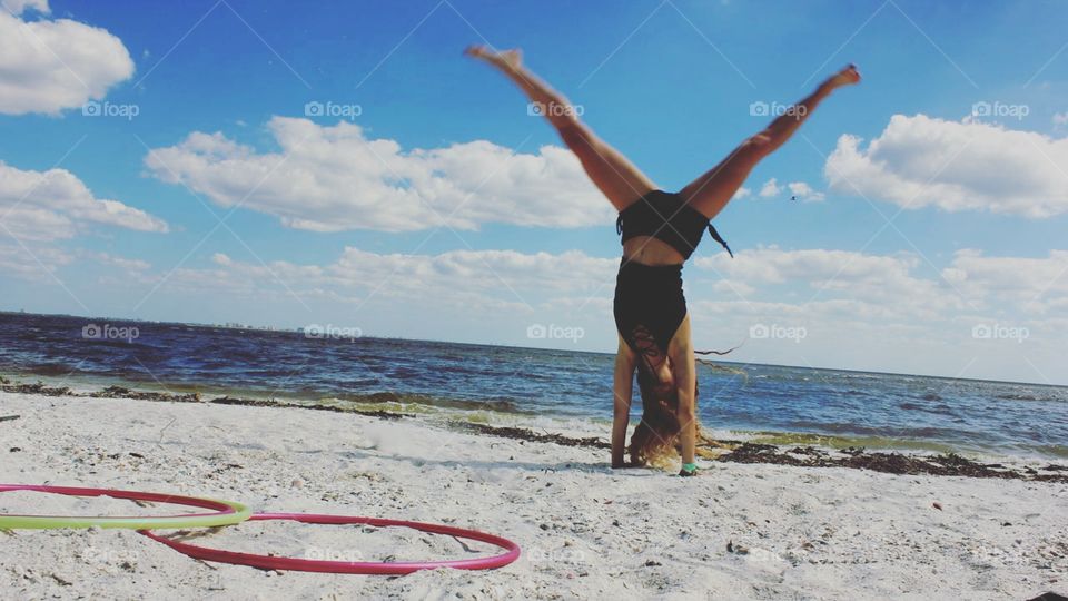 girl mid cartwheel on the beach