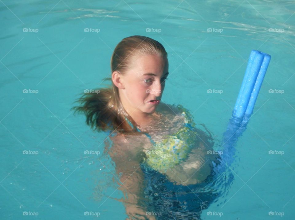 Young girl with a funny face in swimming pool