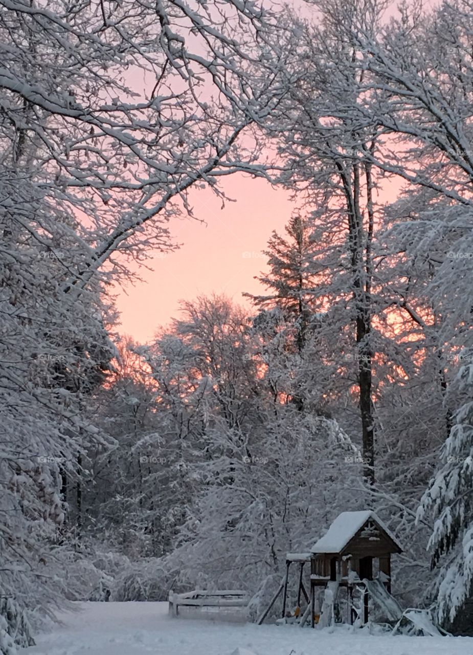 The sun sets after a day of fresh snowfall.