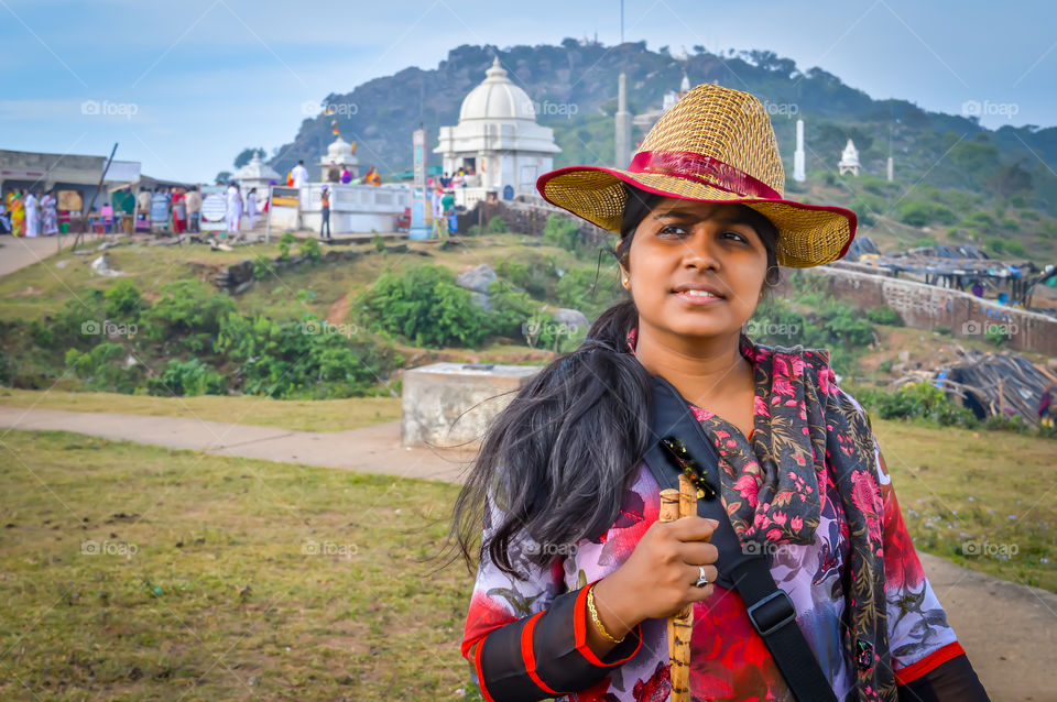 Hipster young girl with backpack enjoying beauty of nature on peak of mountain with background view concept. Beautiful fit young woman hiking up a mountain and enjoying.