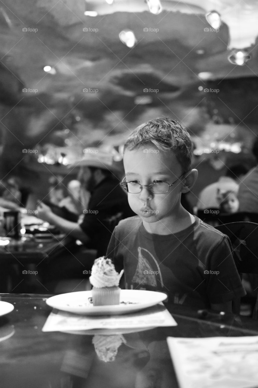 Portrait of a boy blowing a dessert