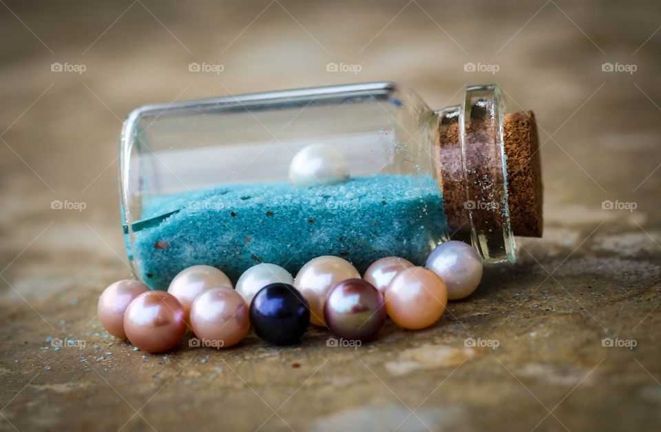 Mermaid treasure. This is a assortment of beautifully colored pearls and one stuck in a jar of sand. 