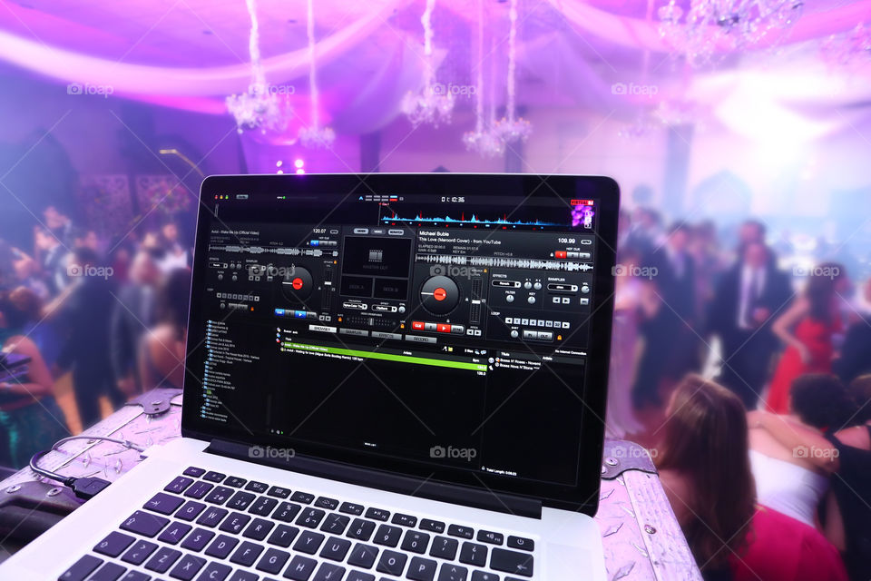 Deejay app playing on laptop at a party