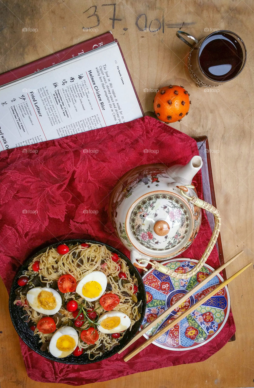 Oriental style meal with noodles, eggs and tea