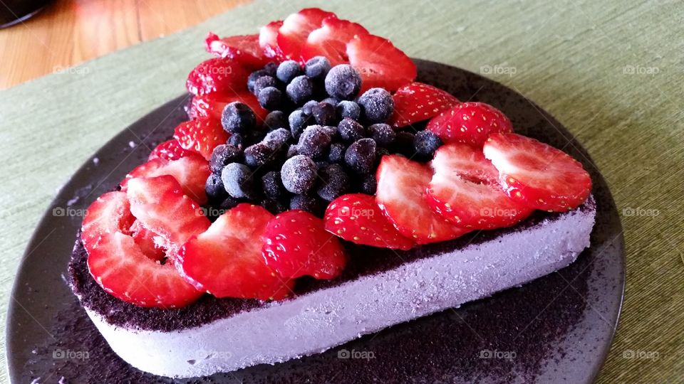 A heartshaped raw vegan cake with frozen blueberrise