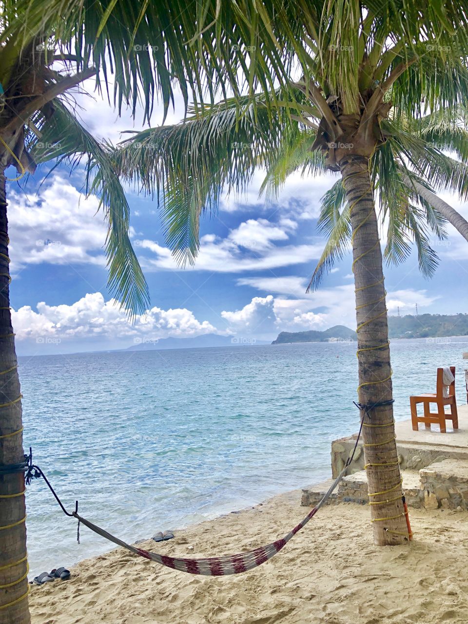 Two palm trees and a hammock on an island