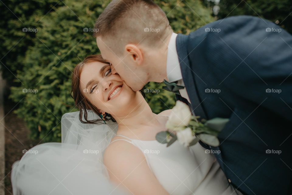 Photographing a casual kiss of the bride and groom during the wedding