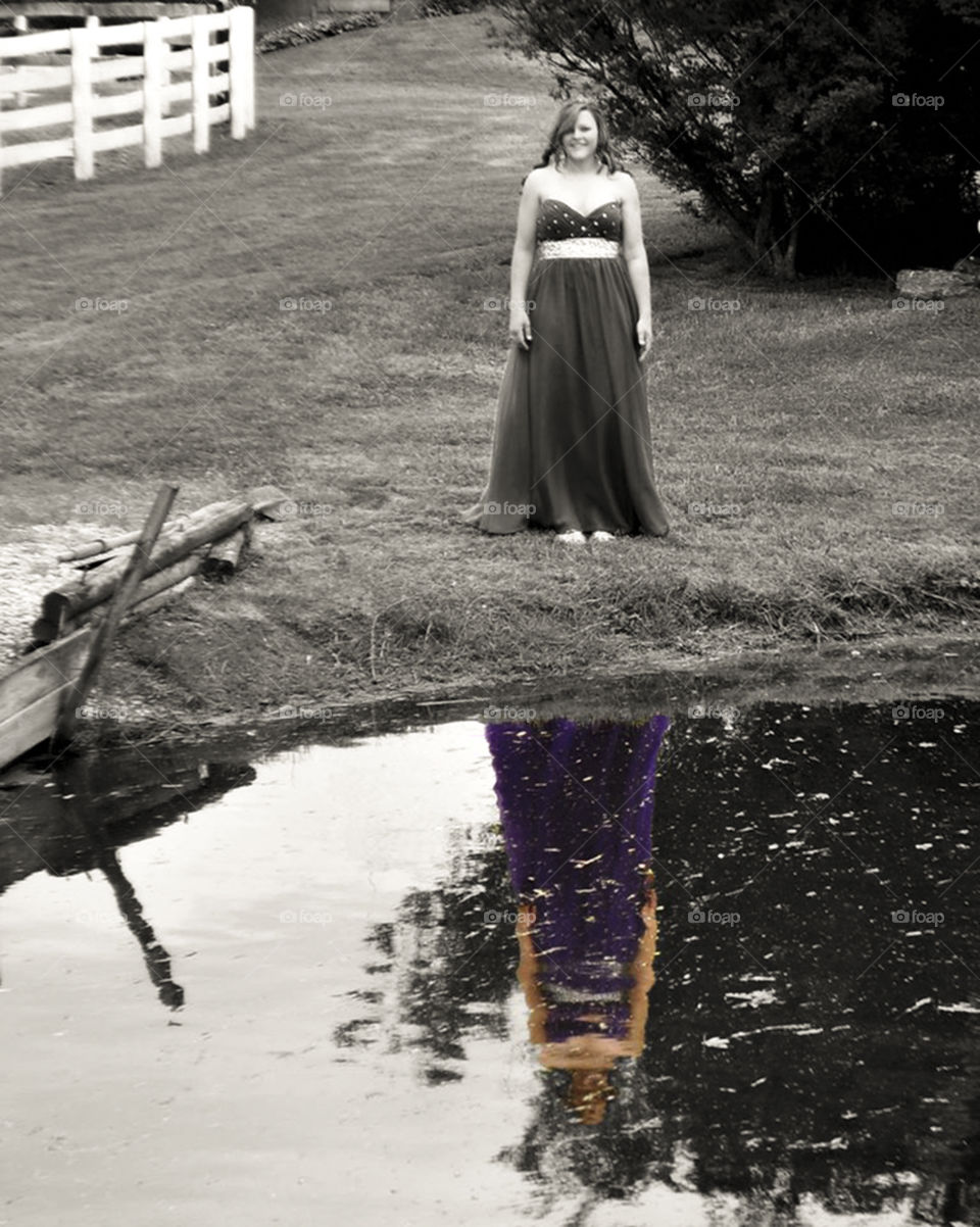 prom reflection. young girl sees her  beautiful reflection in a pond