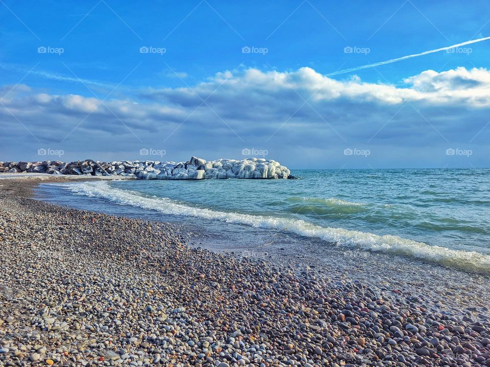 Scenic view of the snow covered rocks at the beautiful beach near Ontario lake,  Toronto. Blue sky. Winter landscape