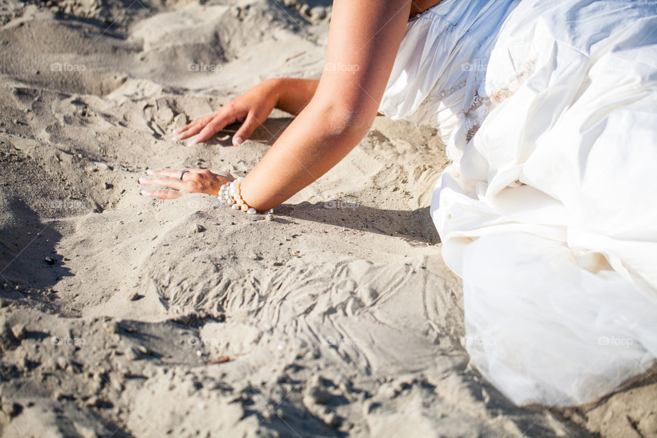 Bride in her wedding dress in the sand on a beach