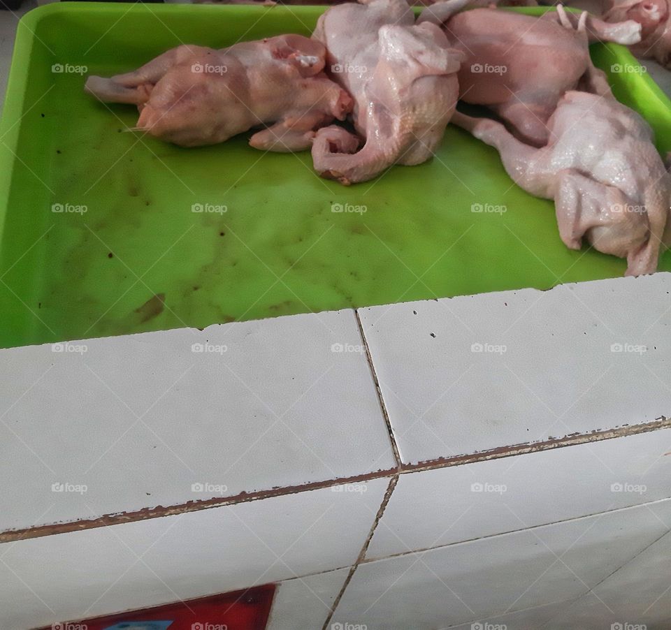 chicken meat placed on the green plastic rectangular board
