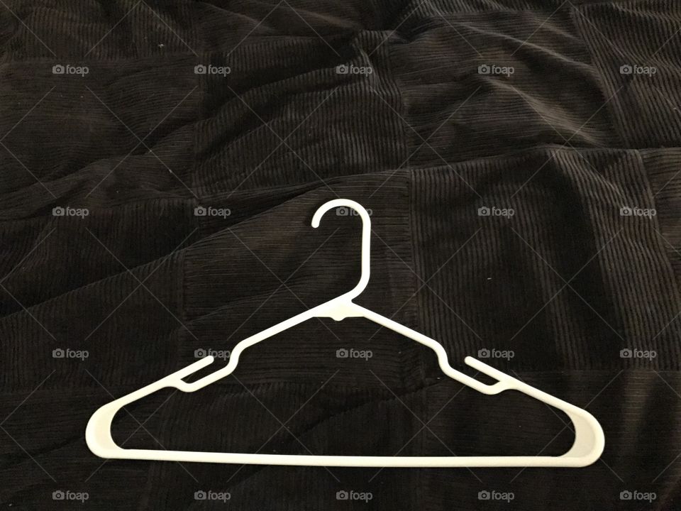 Single white hanger on a black textured background 