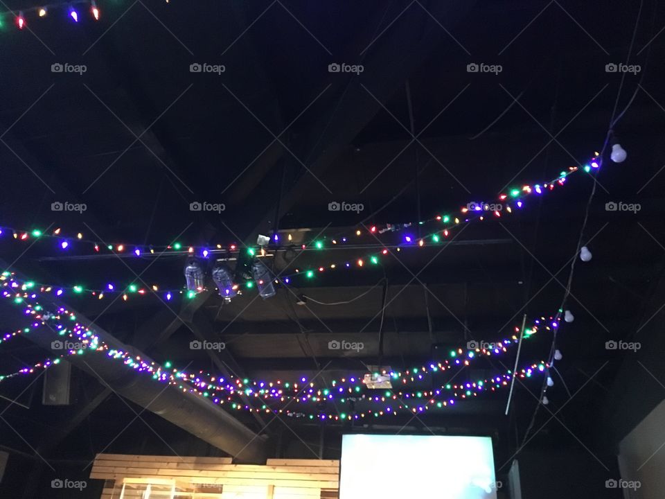 Several strings of Christmas lights hanging from the ceiling of our church 