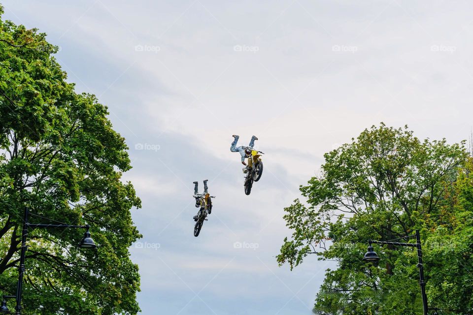 Motorbike riders fly through the sky