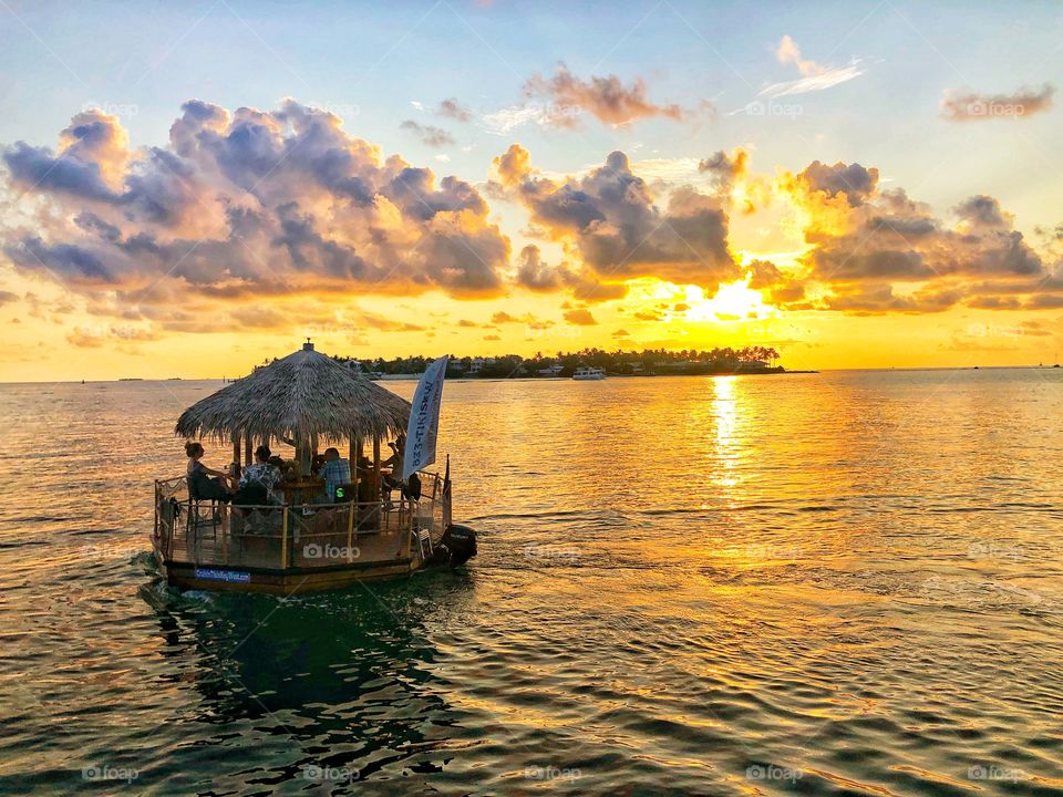 Tiki bar boat floating into the sunset