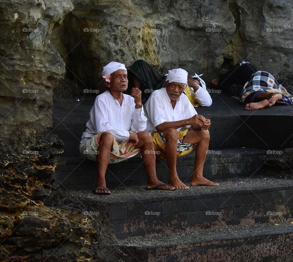 Group of people resting on stair near rock
