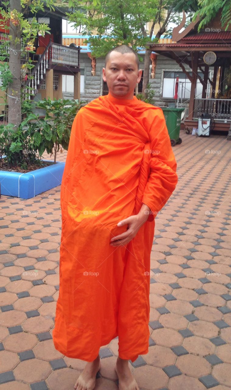 A new monk. The monk is a priest of the Buddhist faith. Buddhism is the main religion of Thailand.