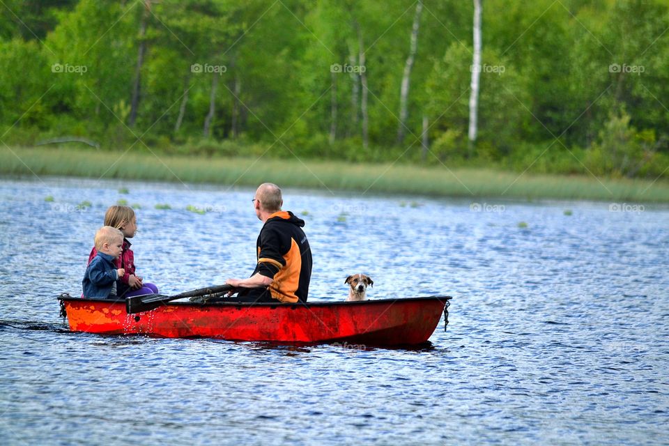 Father and children's riding boat with dog