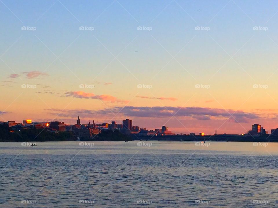 River and city buildings at sunset 