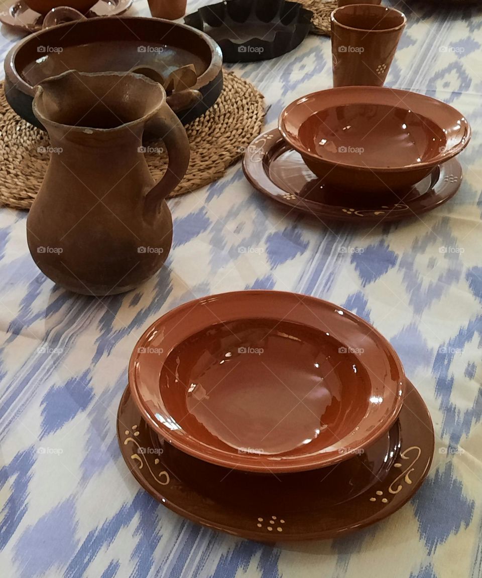 Traditional ceramic tableware, plates and jar. Majorcan blue and white tablecloth of "llengües" of ikat style.