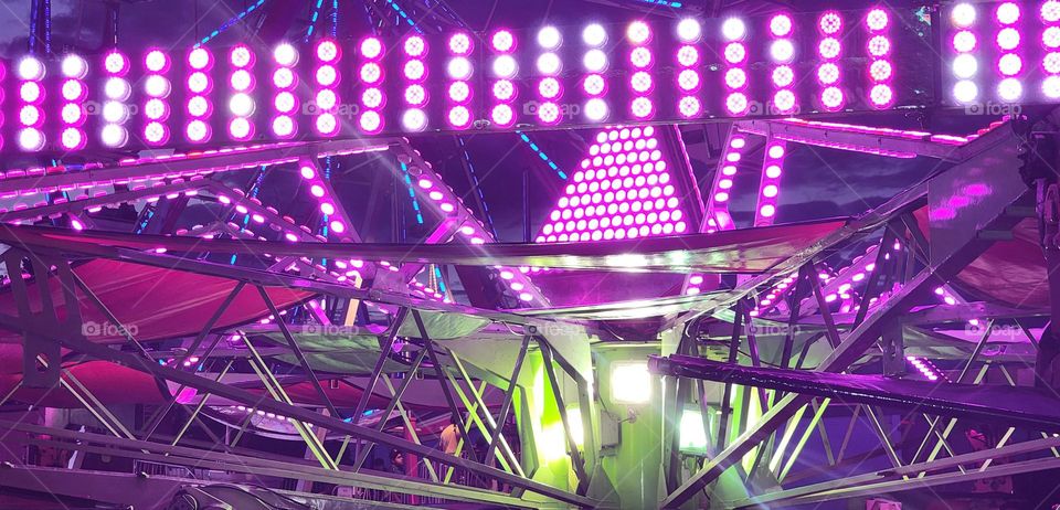 bright pink lights on a hang glider style ride at night in an Oregon county Summer fair