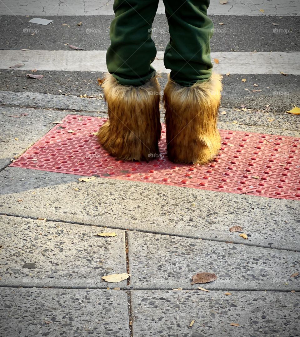 A woman’s fashion boots waiting to cross the street at NYC