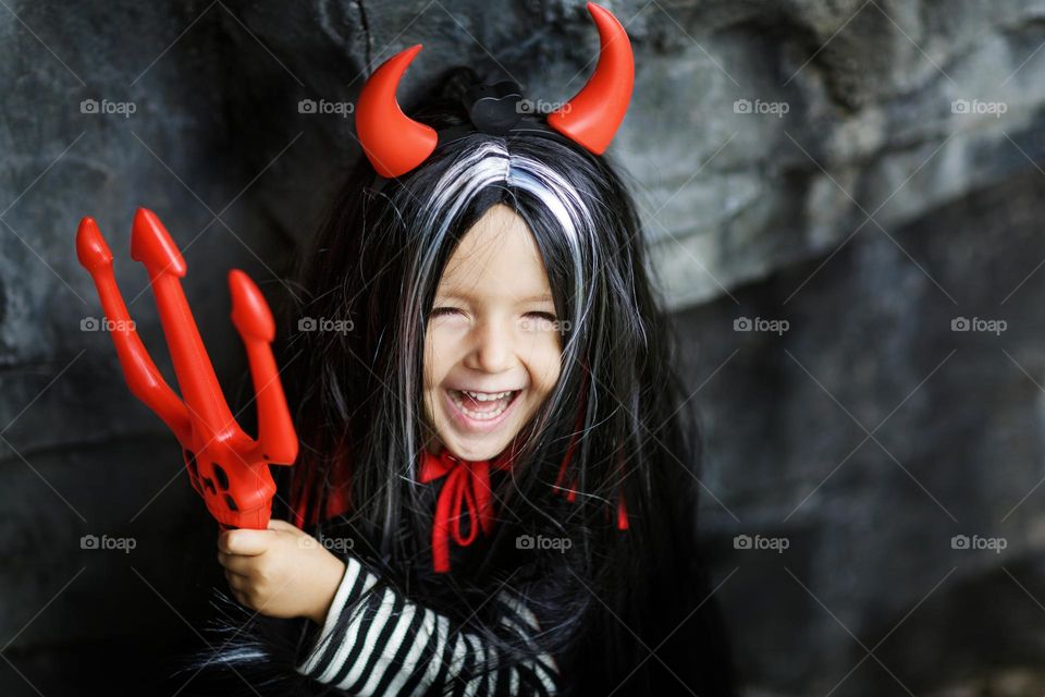 Happy kid in evil costume celebrating Halloween 