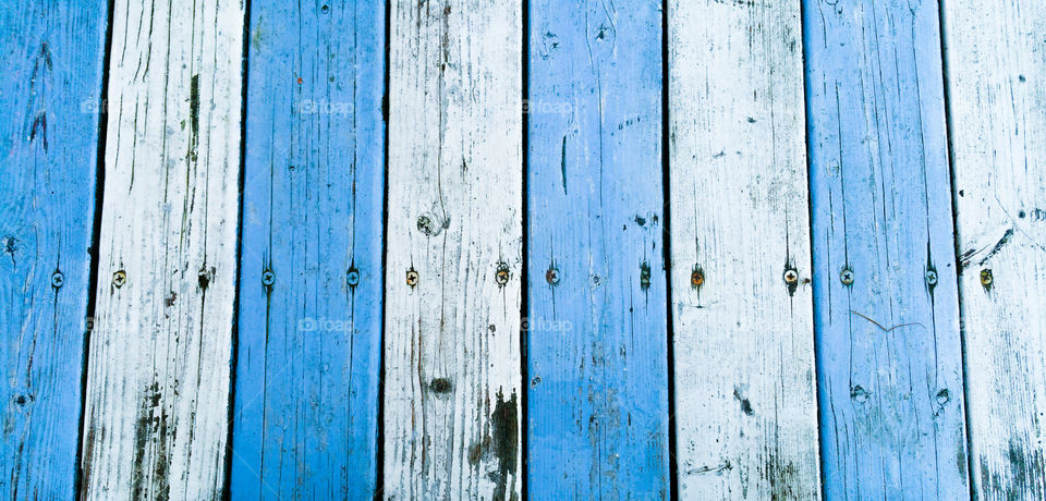 Wooden surface with painted white and blue stripes