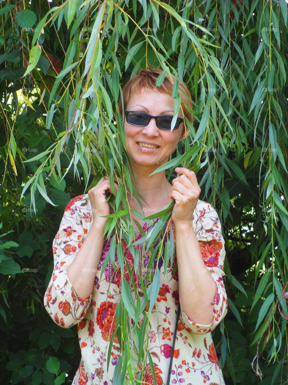 portrait of a girl with glasses on a background of foliage